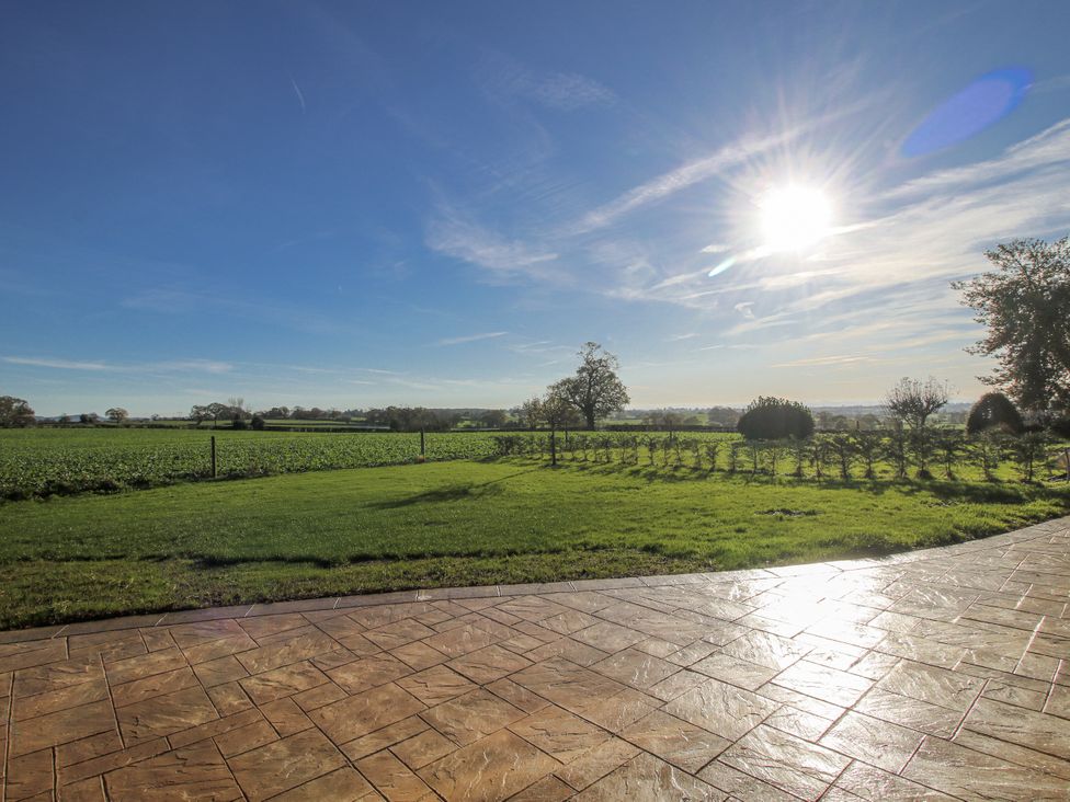 A view of fields and sun from a patio at Garden Cottage in Cockshutt