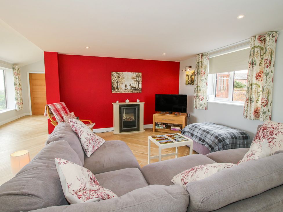 A living room with a sofa and television at Garden Cottage in Cockshutt
