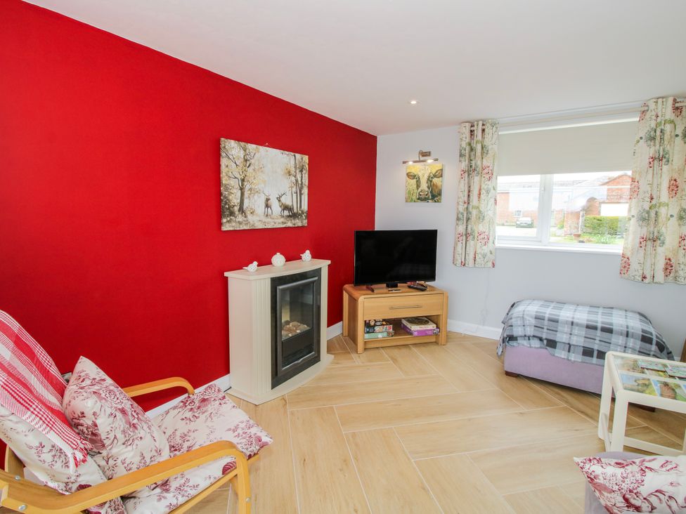A living room with a television and fireplace at Garden Cottage in Cockshutt