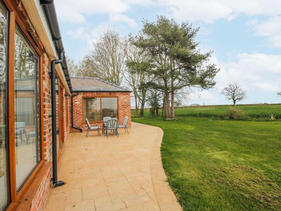 A patio area with chairs and a table at Garden Cottage in Cockshutt