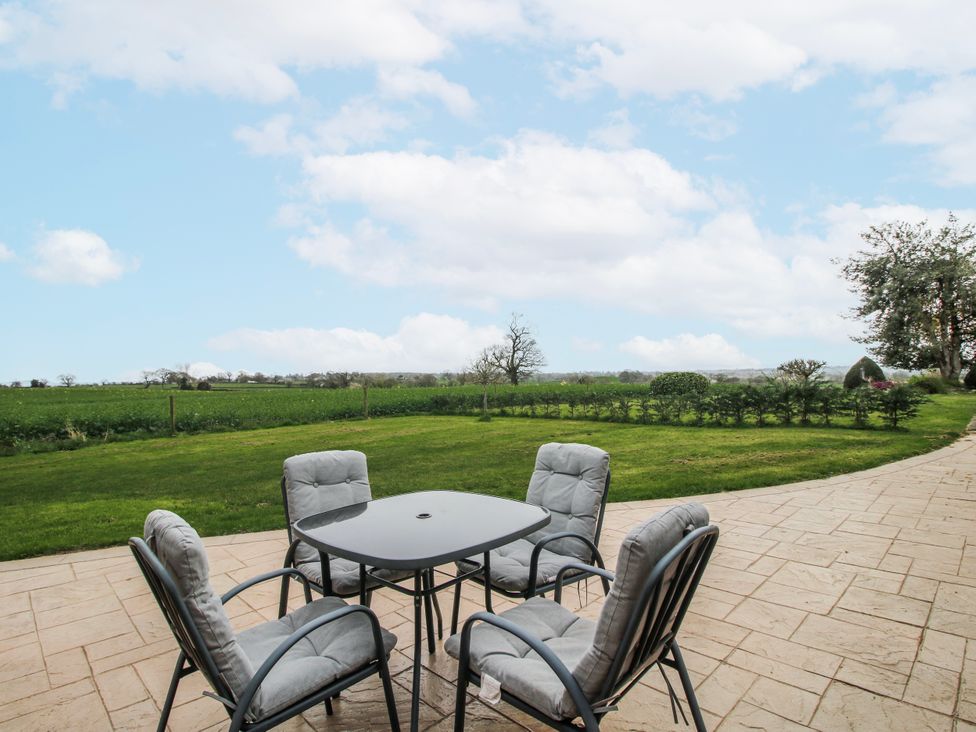 An outdoor seating area with a table and chairs at Garden Cottage in Cockshutt