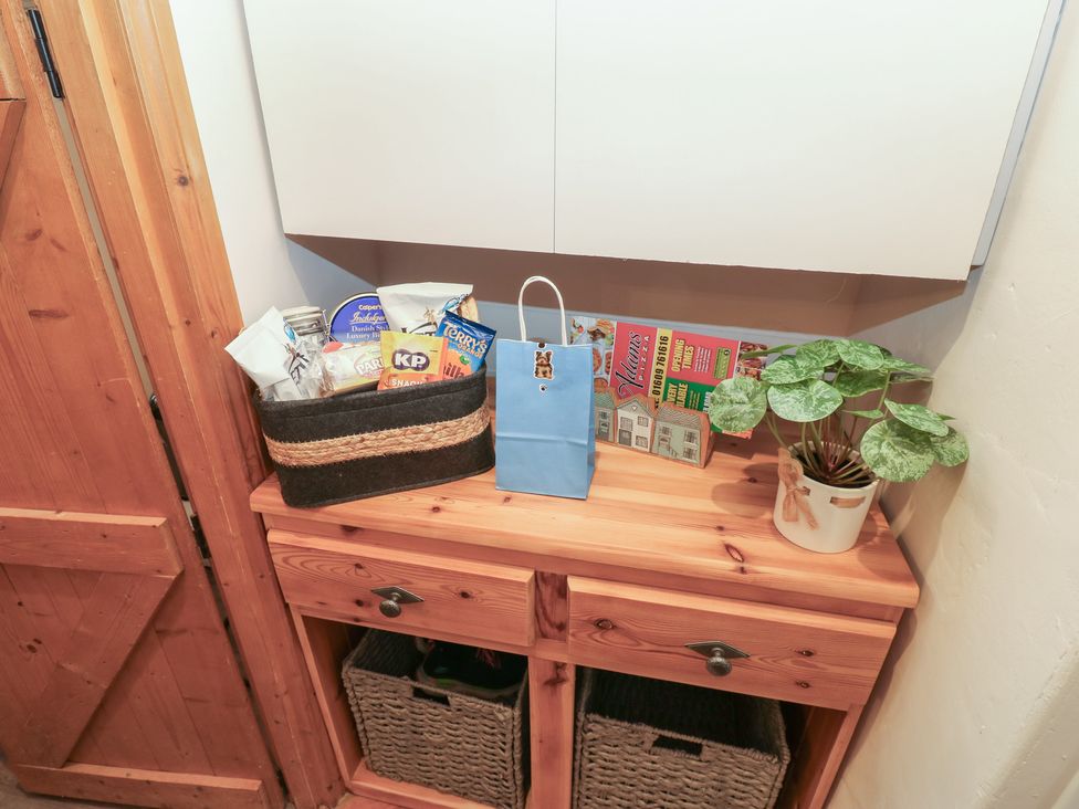 A snack basket and plant pot on a wooden cabinet at 57 Cockpit Hill Northallerton