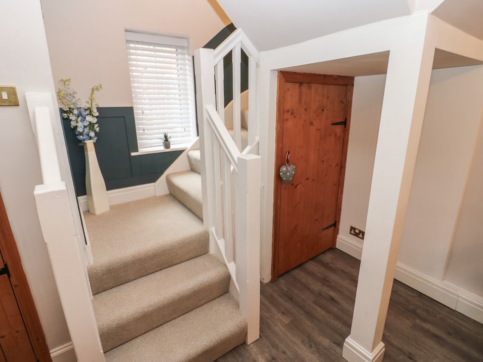 A hallway with stairs and a door at 57 Cockpit Hill in Northallerton