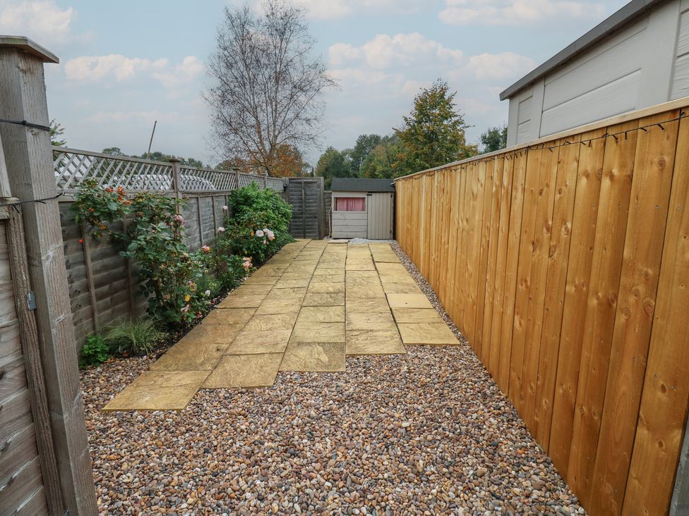 A garden with a stone pathway and a shed at 57 Cockpit Hill in Northallerton
