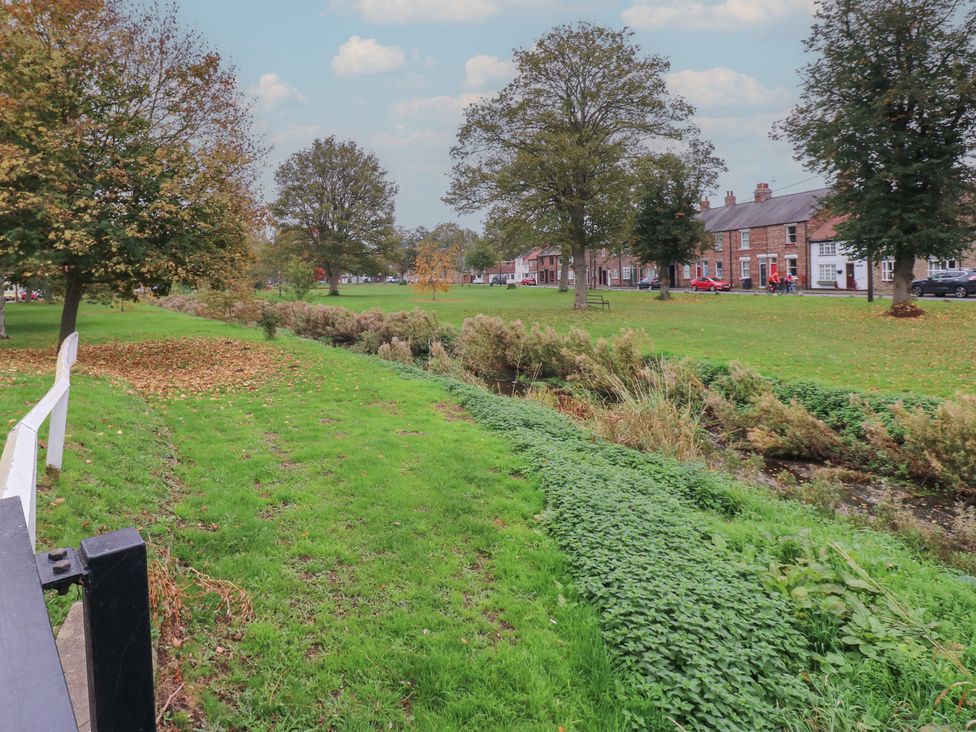 An outdoor scene with trees and a stream at 57 Cockpit Hill Northallerton