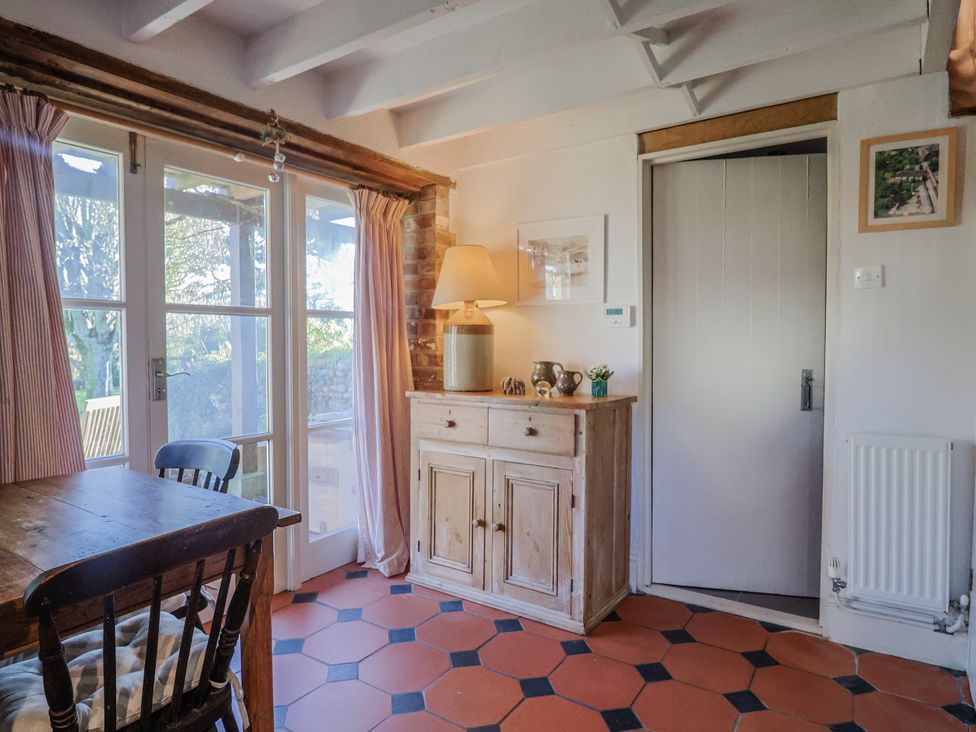 A dining room with a table and cabinet at The Little Barn Fluxton Nr. Ottery St Mary