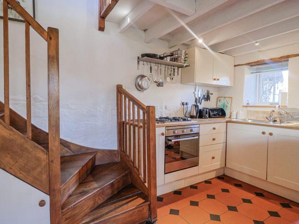 A kitchen with a staircase and appliances at The Little Barn Fluxton Nr. Ottery St Mary