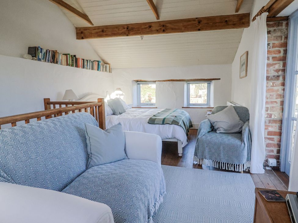 A bedroom with a sofa and two beds at The Little Barn Fluxton Nr. Ottery St Mary