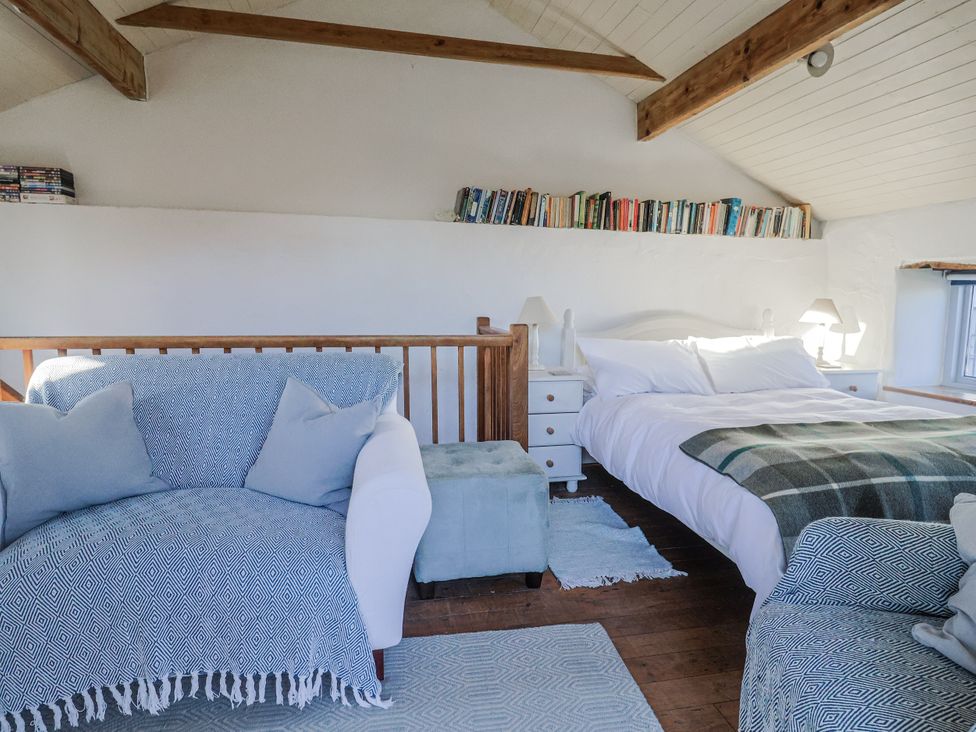 A bedroom with a bed and sofa at The Little Barn in Fluxton Nr. Ottery St Mary