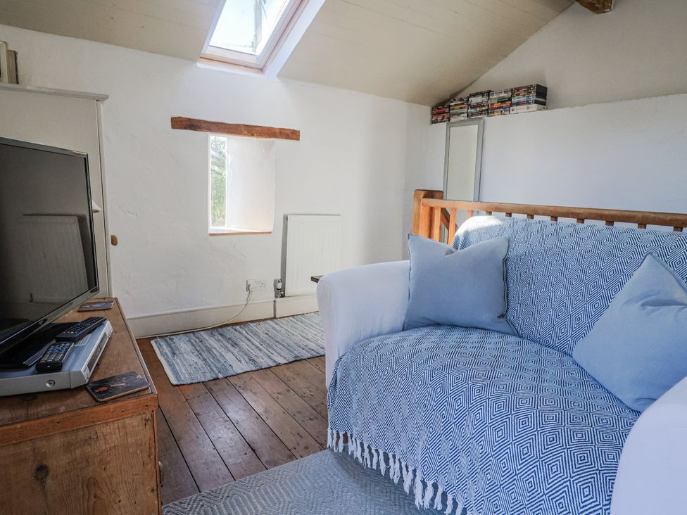 A living room with a sofa and television at The Little Barn in Fluxton Nr. Ottery St Mary