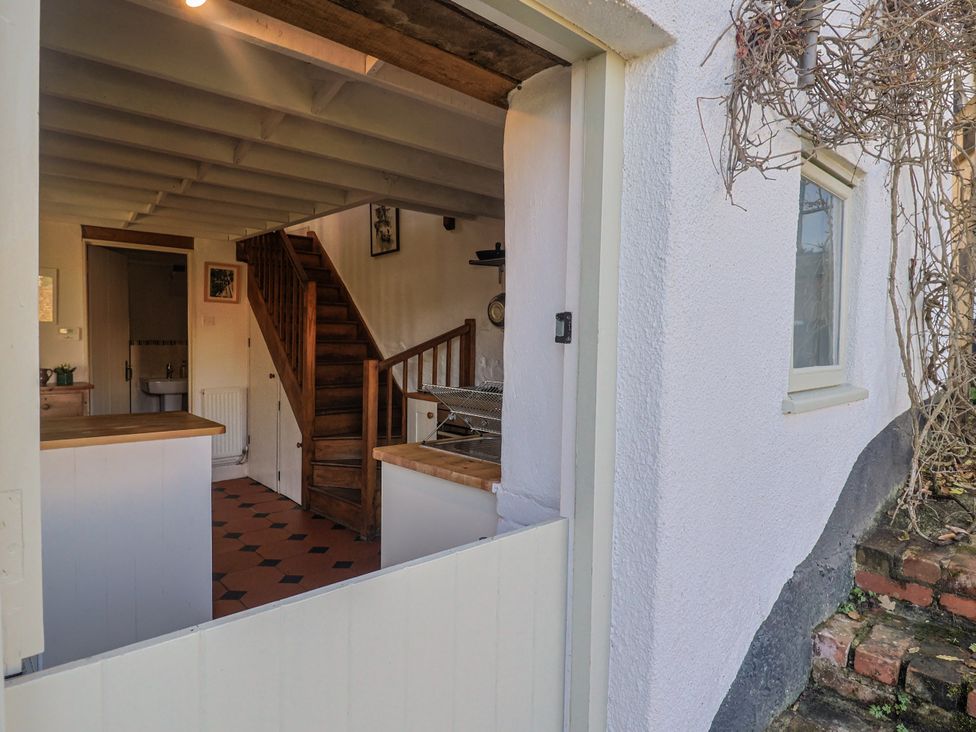 A kitchen with a staircase visible from the entrance at The Little Barn in Fluxton Nr. Ottery St Mary