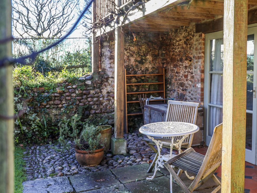 An outdoor seating area with a table and chairs at The Little Barn Fluxton Nr. Ottery St Mary