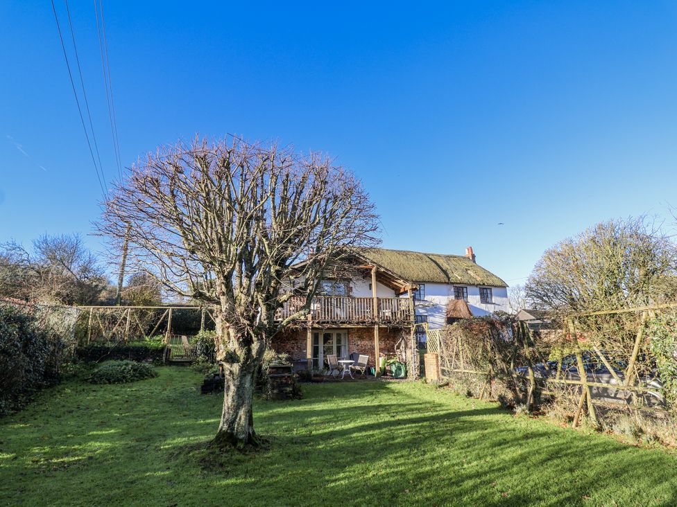 A house with a balcony and tree in the garden at The Little Barn Fluxton Nr. Ottery St Mary