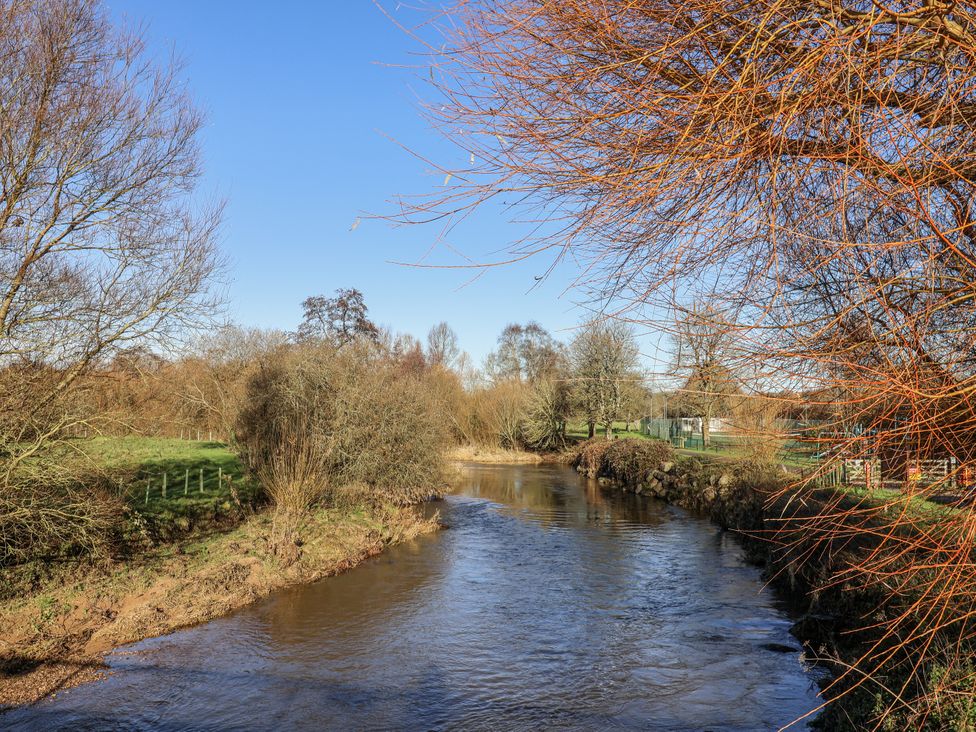 A river flowing through trees and grass at The Little Barn Fluxton Nr. Ottery St Mary