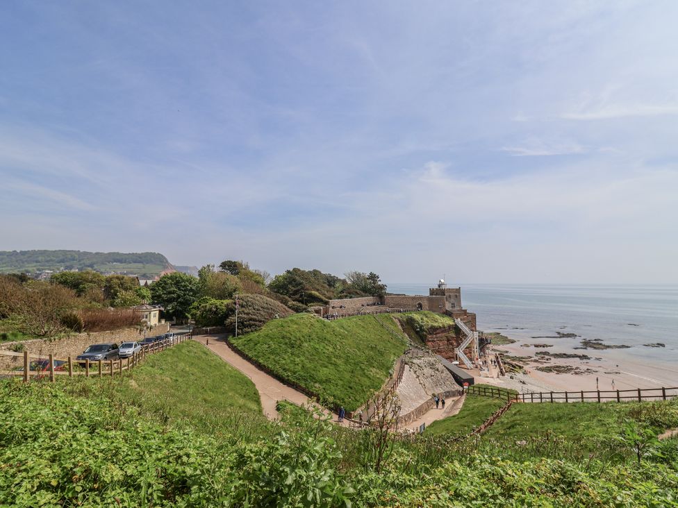 A view of a lighthouse on a cliff beside the ocean at The Little Barn Fluxton Nr. Ottery St Mary