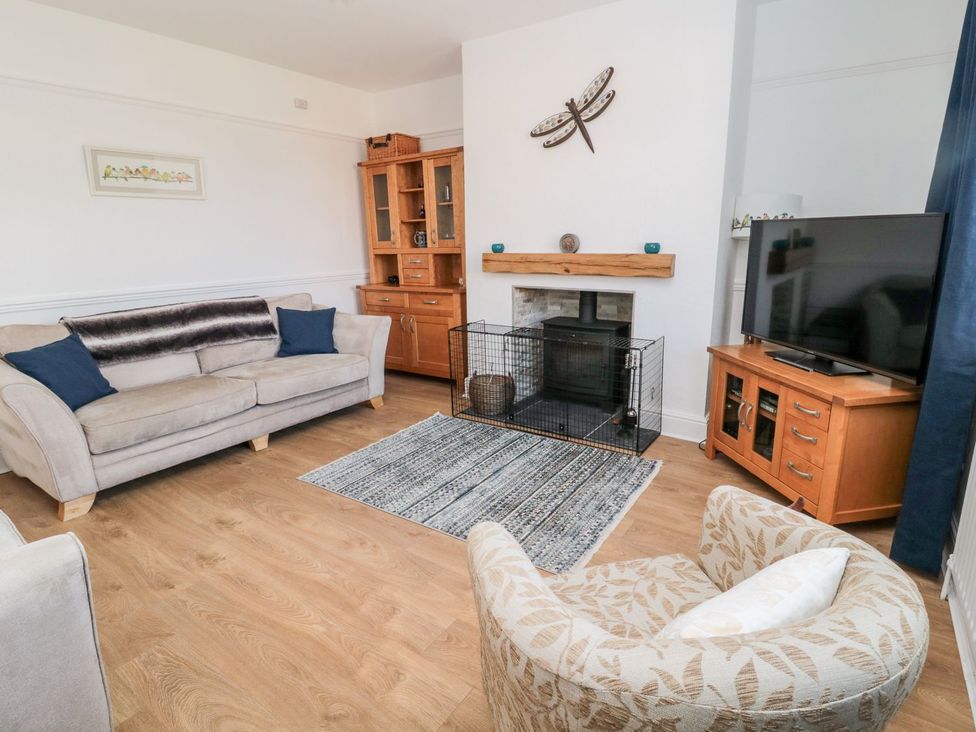 A living room with a sofa and television at 23 Northumbria Terrace Amble