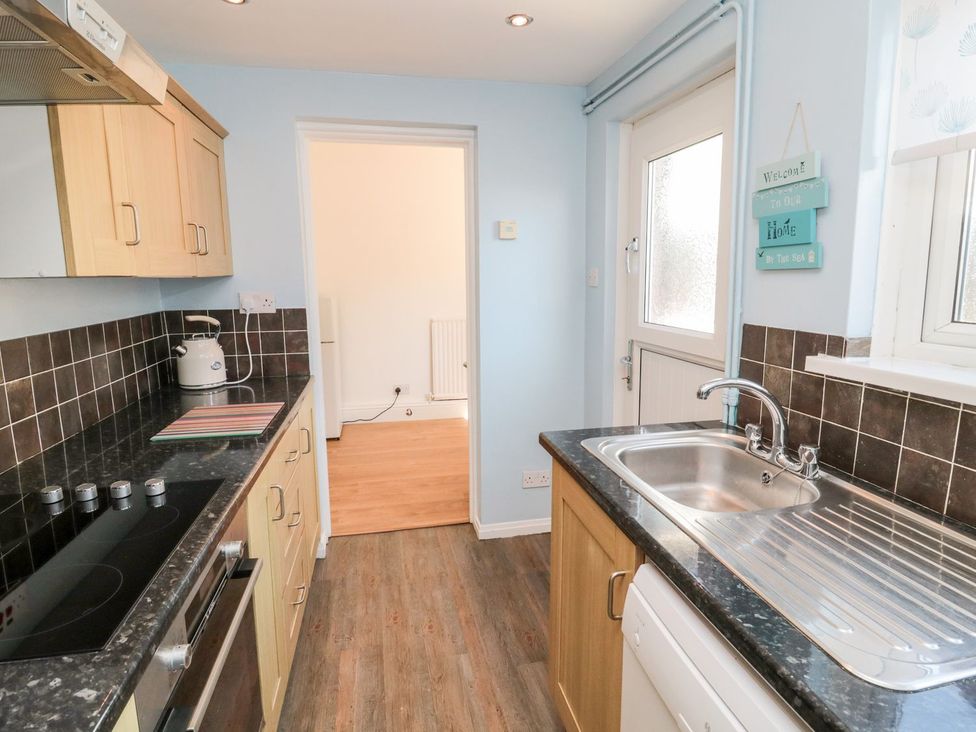 A kitchen with cabinets and a sink at 23 Northumbria Terrace Amble