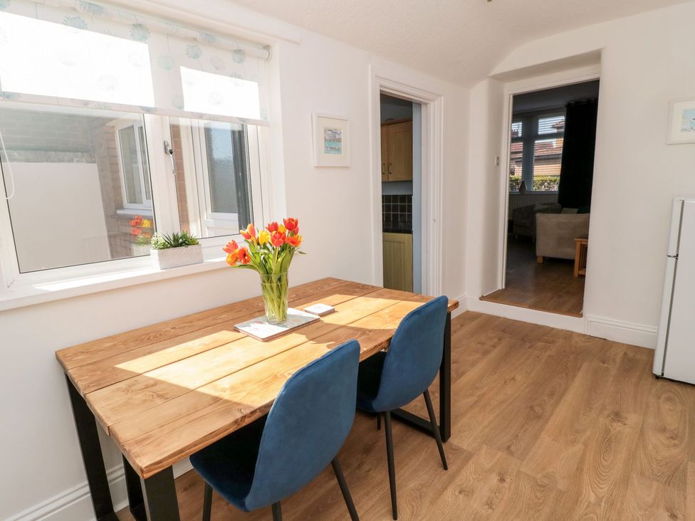 A dining room with a wooden table and chairs at 23 Northumbria Terrace Amble