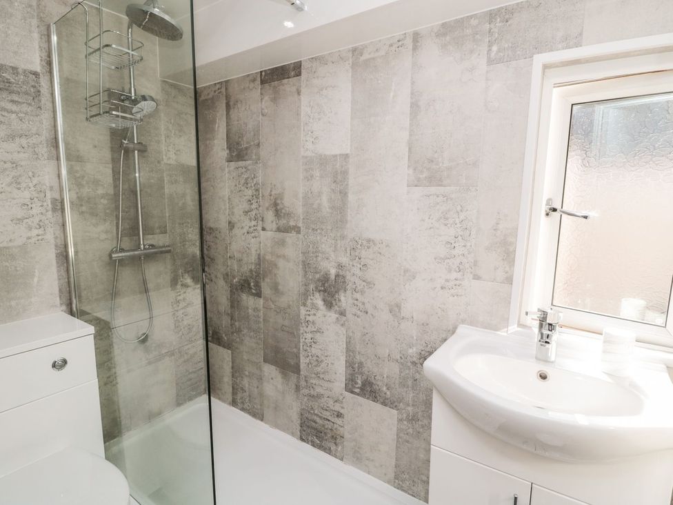 A bathroom with a shower and sink at 23 Northumbria Terrace Amble