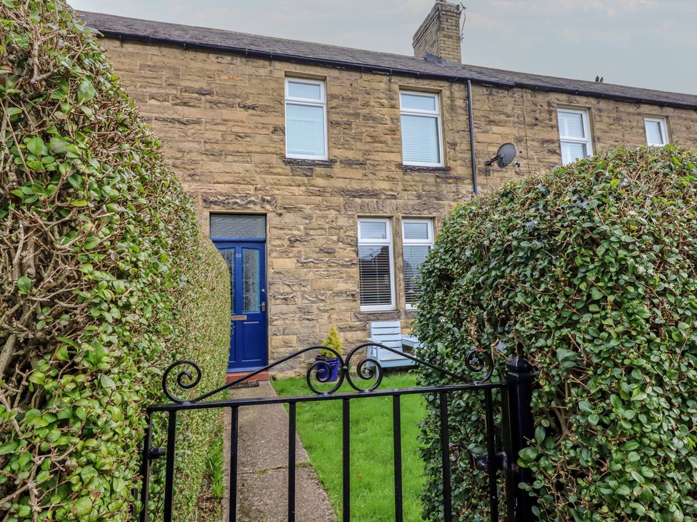 An exterior view of a house with a pathway and hedges at 23 Northumbria Terrace Amble