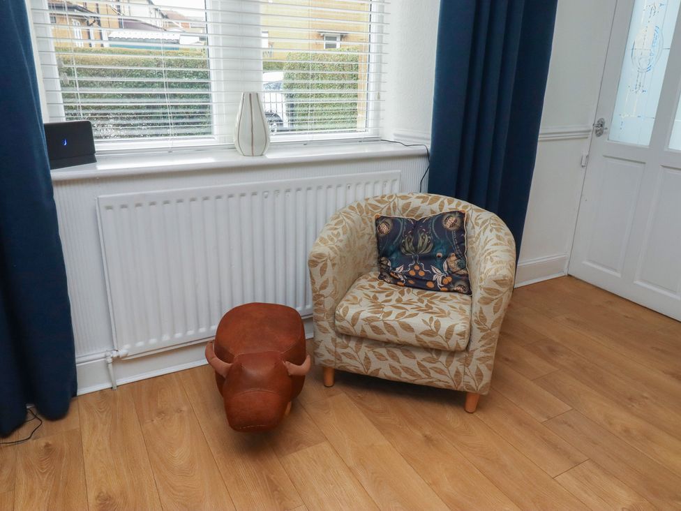 A living room with a chair and decorative objects at 23 Northumbria Terrace in Amble