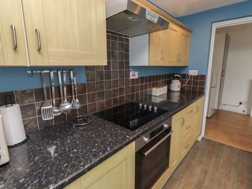 A kitchen with cabinets and a stove at 23 Northumbria Terrace Amble