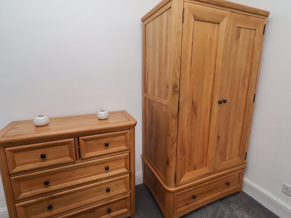 A chest of drawers and wardrobe in a bedroom at 23 Northumbria Terrace in Amble