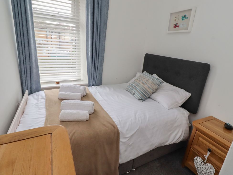 A bedroom with a bed and towels on it at 23 Northumbria Terrace Amble