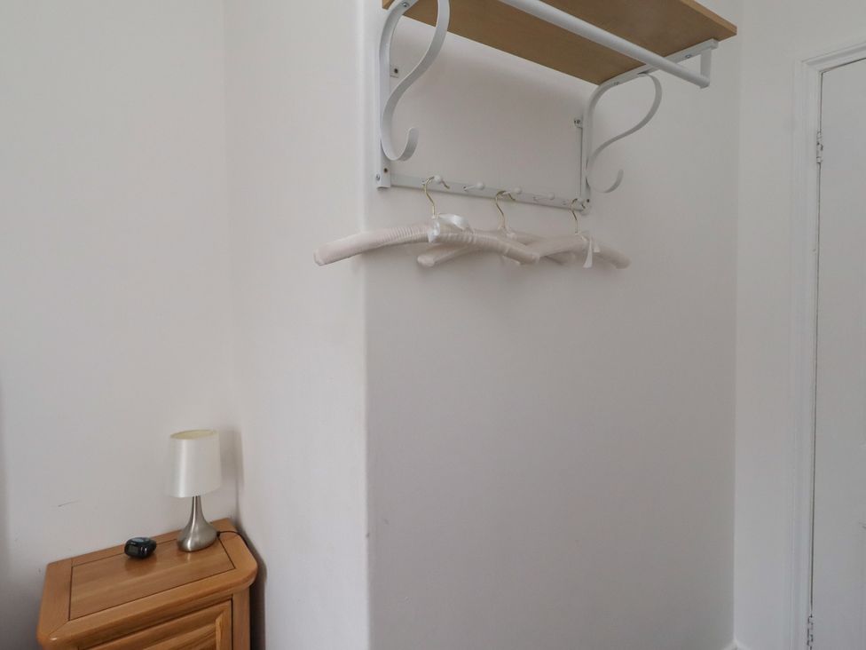 A clothes rack and lamp in a bedroom at 23 Northumbria Terrace Amble
