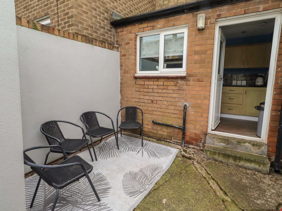 A garden with chairs and a doorway at 23 Northumbria Terrace Amble