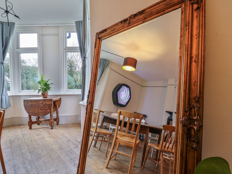 A dining room with a mirror, chairs, and a table at The Farmhouse in Whitchurch, Buckinghamshire