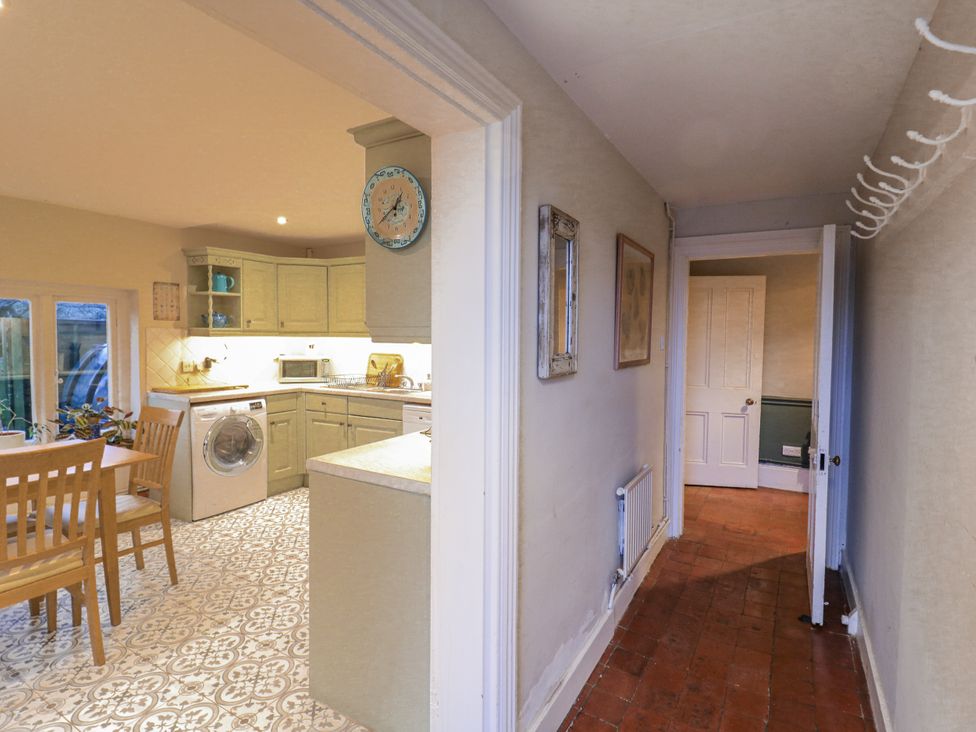 A kitchen with a dining table and washing machine at The Farmhouse in Whitchurch, Buckinghamshire