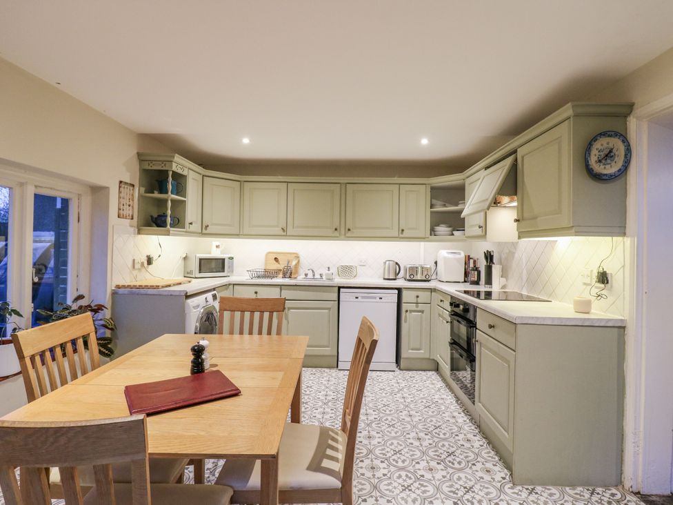 A kitchen with a dining table and appliances at The Farmhouse in Whitchurch, Buckinghamshire