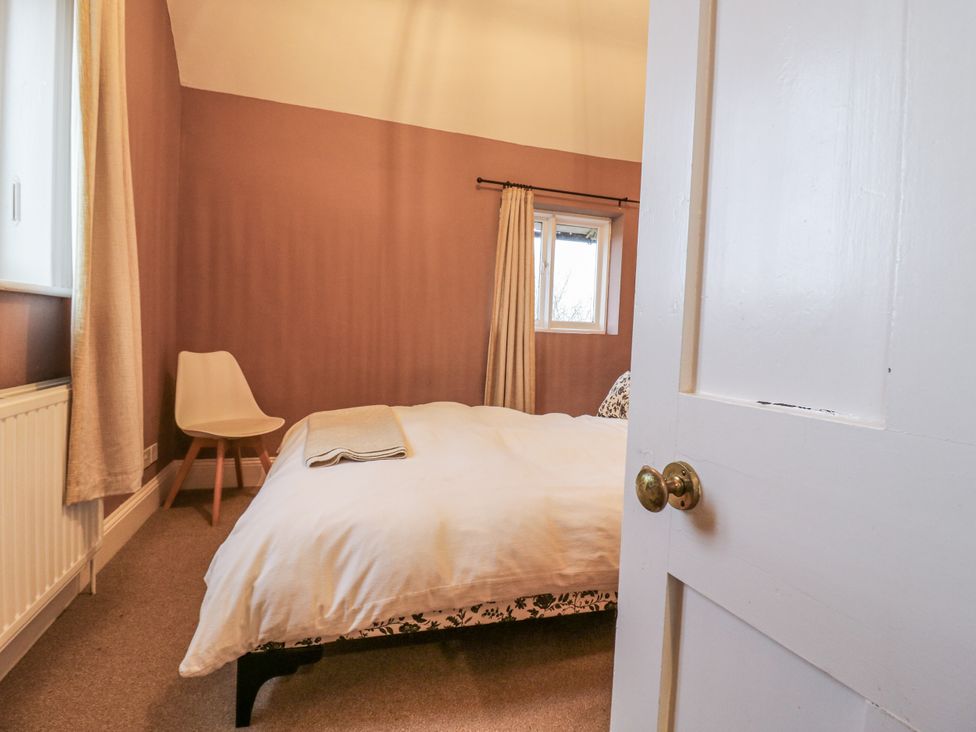 A bedroom with a bed and chair at The Farmhouse in Whitchurch, Buckinghamshire