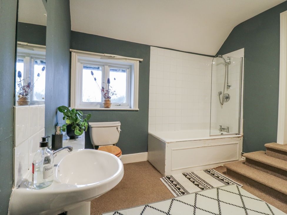A bathroom with a bath tub, sink, toilet, and shower at The Farmhouse in Whitchurch, Buckinghamshire