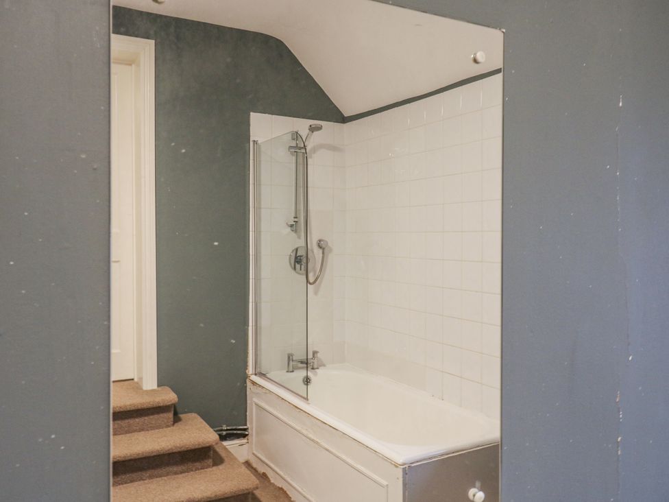 A bathtub with shower in a bathroom at The Farmhouse in Whitchurch, Buckinghamshire