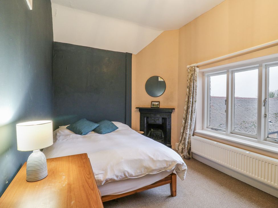 A bedroom with a bed, lamp, and mirror at The Farmhouse in Whitchurch, Buckinghamshire