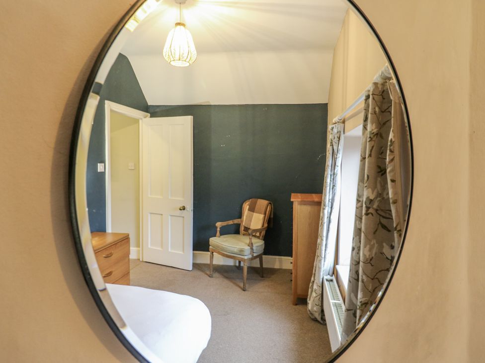 A bedroom with a chair and wardrobe at The Farmhouse in Whitchurch, Buckinghamshire