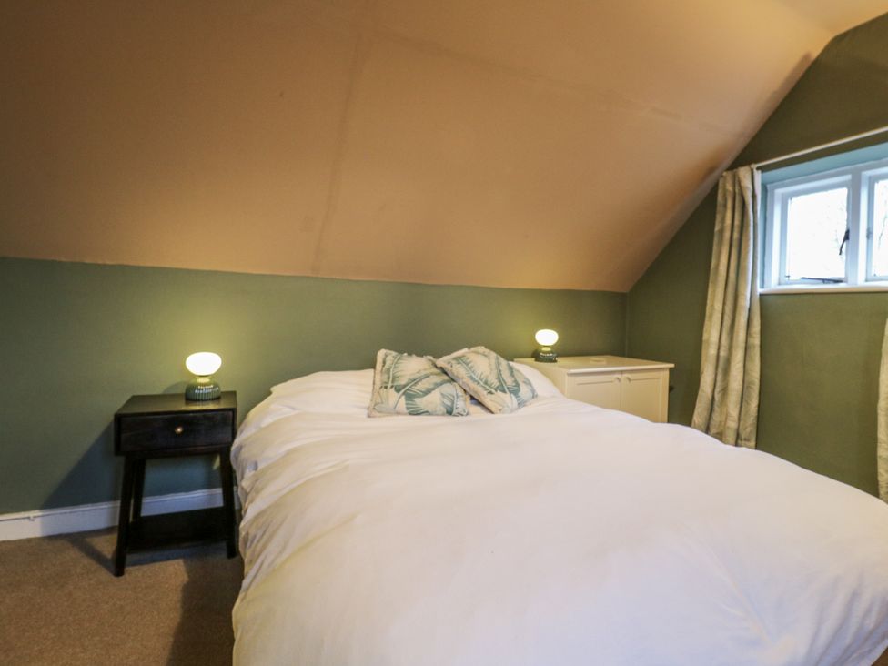 A bedroom with a bed and nightstand at The Farmhouse in Whitchurch, Buckinghamshire