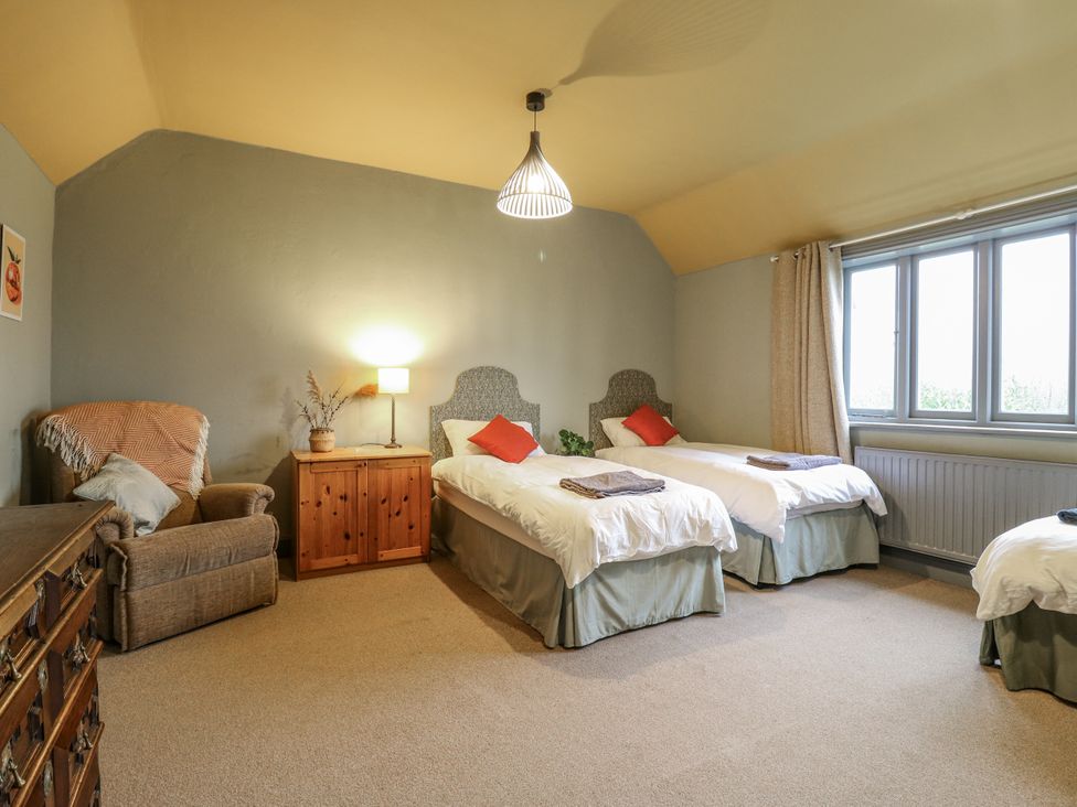 A bedroom with two single beds and a dresser at The Farmhouse in Whitchurch, Buckinghamshire