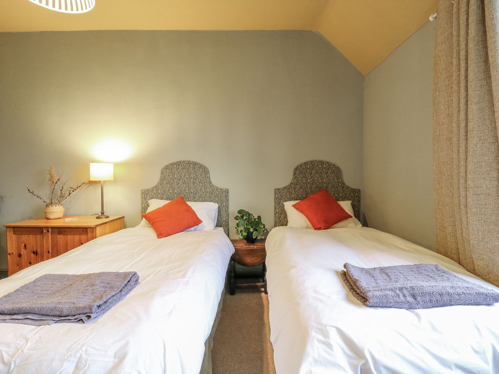 A bedroom with two single beds and a lamp at The Farmhouse in Whitchurch, Buckinghamshire