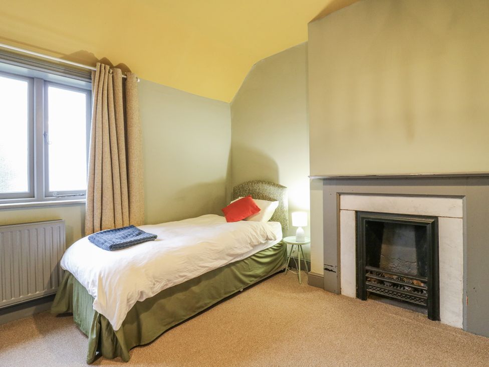 A bedroom with a bed, lamp, and fireplace at The Farmhouse in Whitchurch, Buckinghamshire