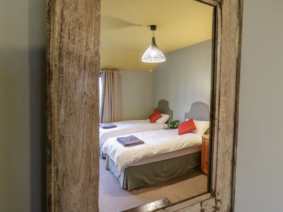 A bedroom with two beds and a wooden cabinet at The Farmhouse in Whitchurch, Buckinghamshire