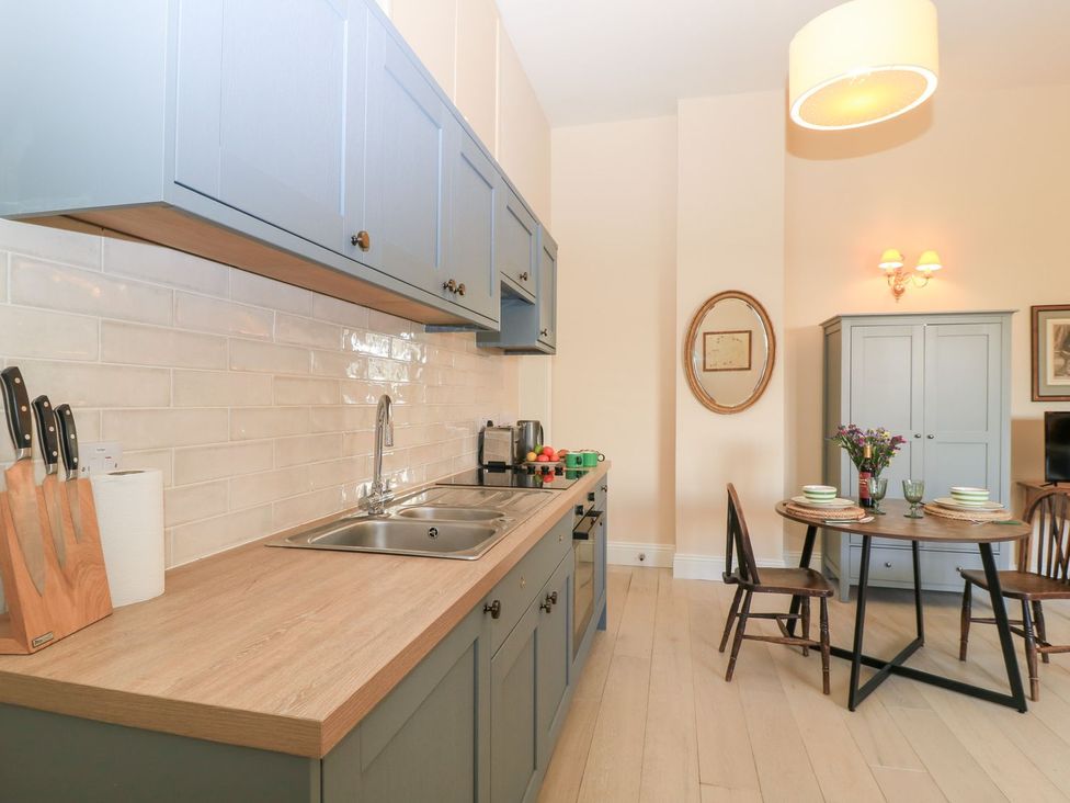 A kitchen with cabinets and dining space at Woodcock Studio in Andoversford near Cheltenham