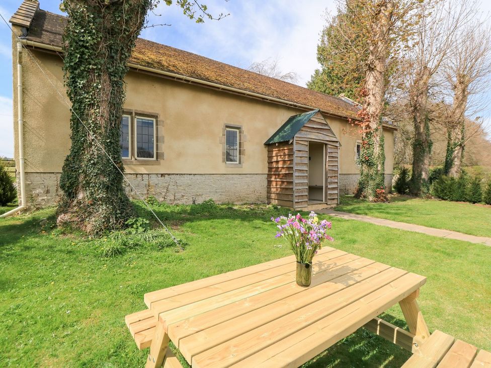 A table with flowers in front of a building at Woodcock Studio in Andoversford near Cheltenham