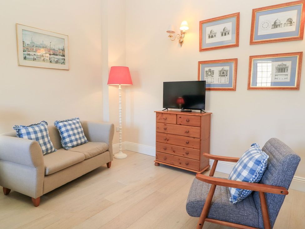 A living room with a television and furniture at Swallow Studio in Andoversford near Cheltenham