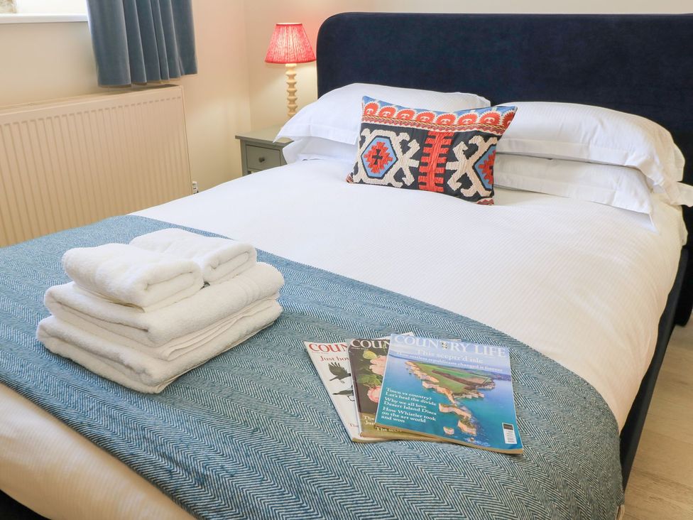 A bedroom with a bed and towels on the covers at Swallow Studio in Andoversford near Cheltenham