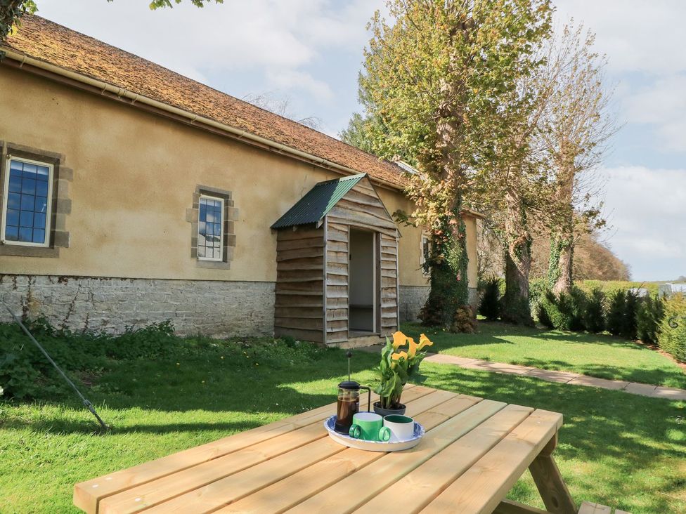 An outdoor area with a table and coffee at Swallow Studio in Andoversford near Cheltenham