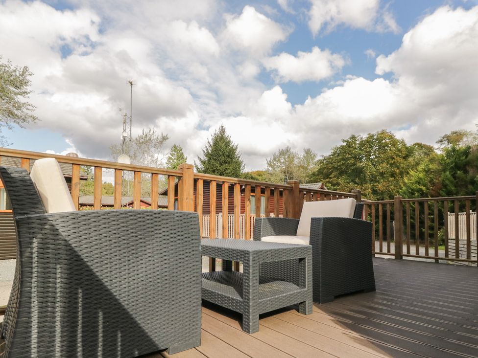 A seating area with chairs and a table on a deck at 32 Grasmere in Windermere