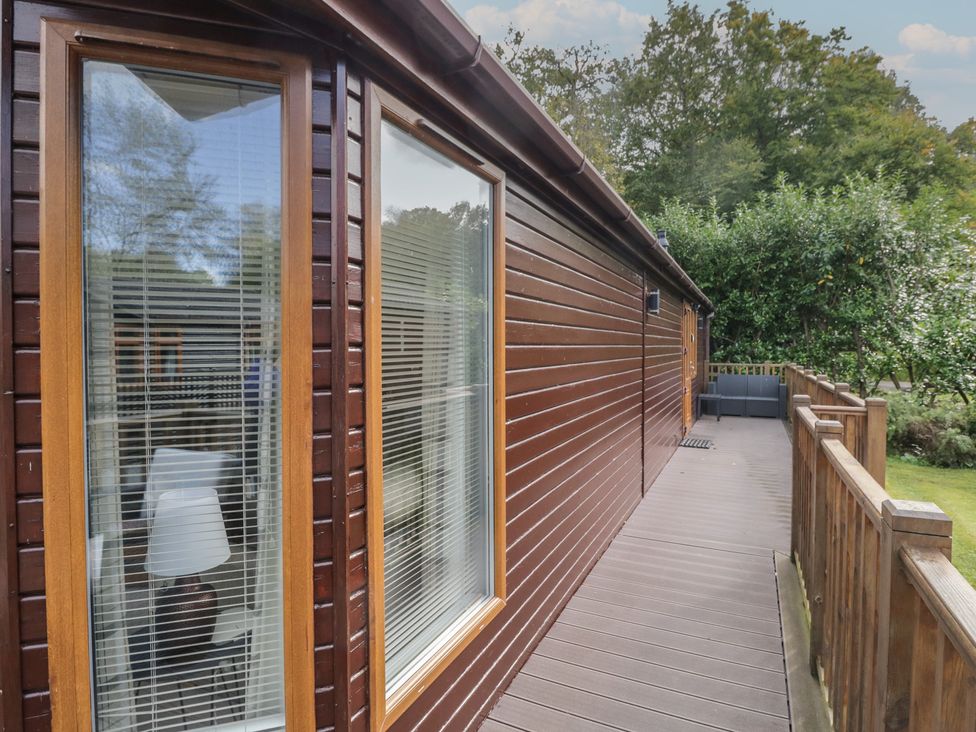 An outdoor view of a wooden deck with windows at 32 Grasmere Windermere